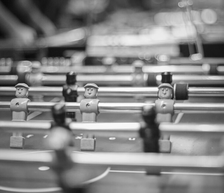 Ein Bild, auf dem männliche Tischkickerfiguren zu sehen sind.